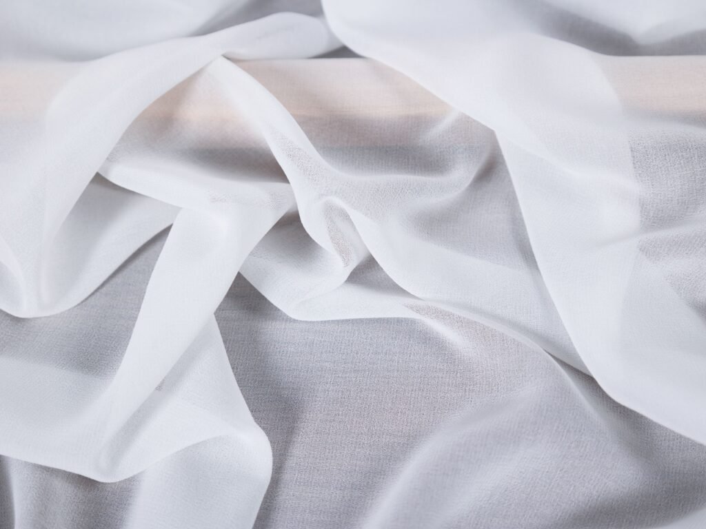 Soft white fabric drapes gracefully, creating a serene and airy texture.